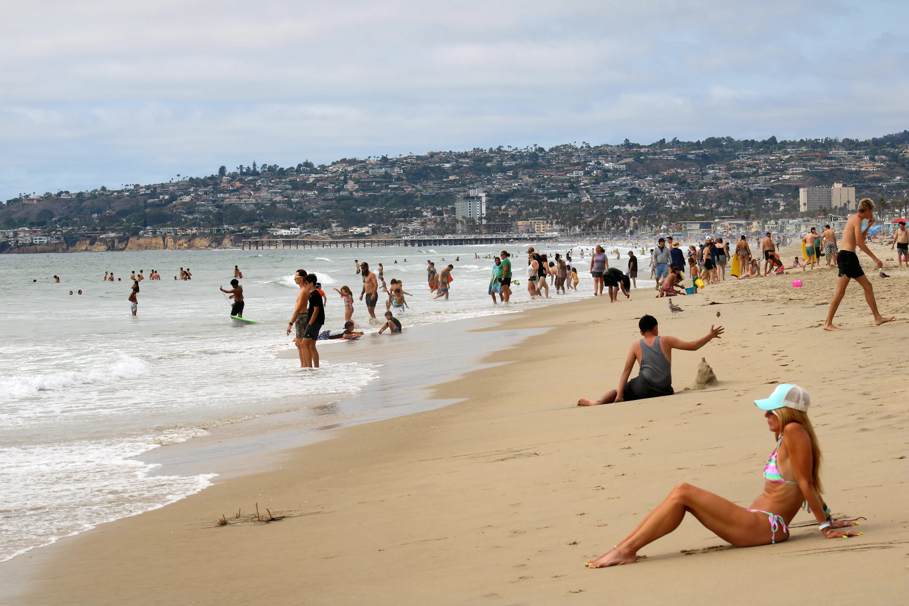 The wide sandy Mission Beach full of beachgoers in San Diego