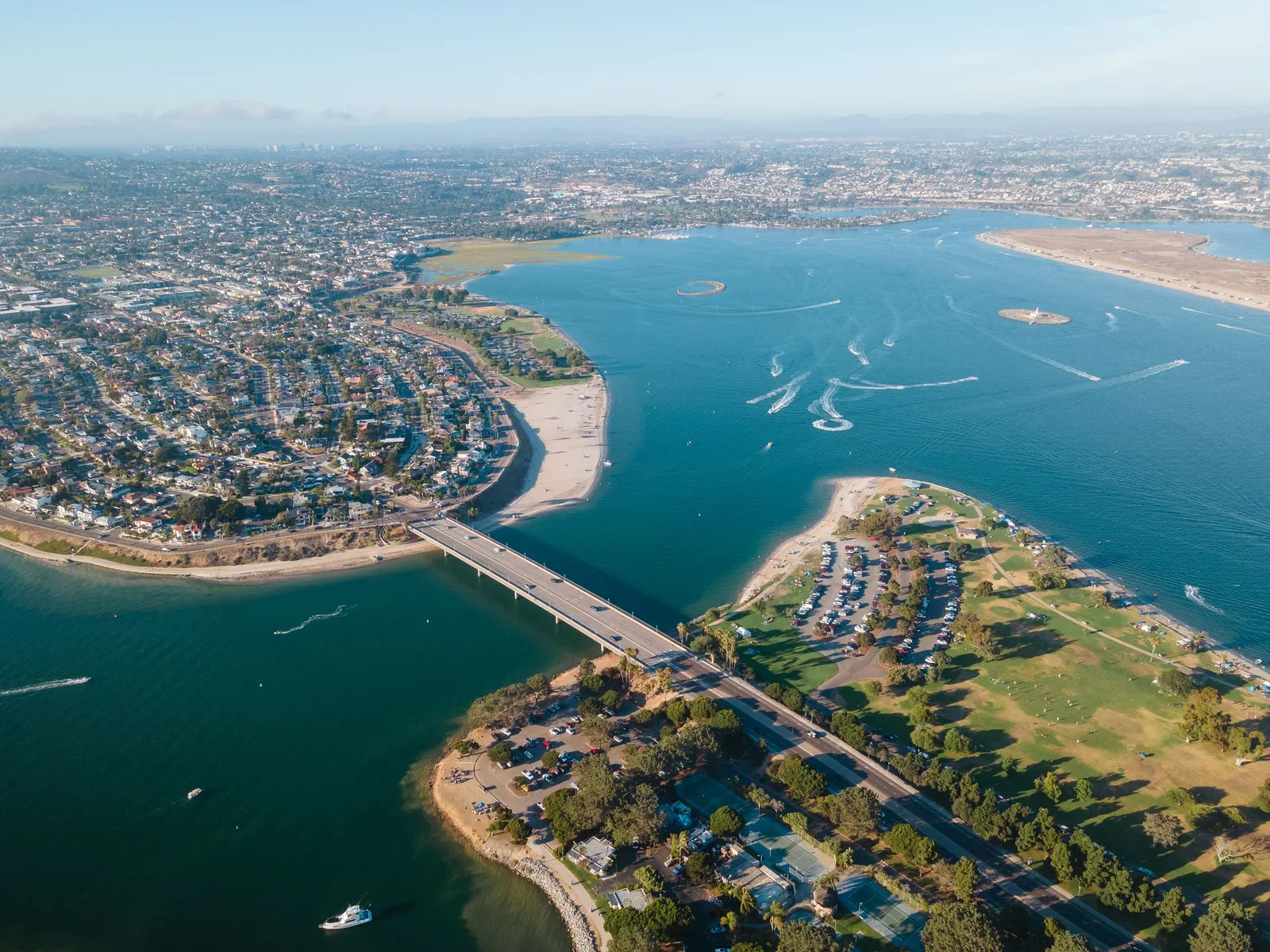 Aerial view of a bridge crossing Mission Bay between a neighborhood and a park