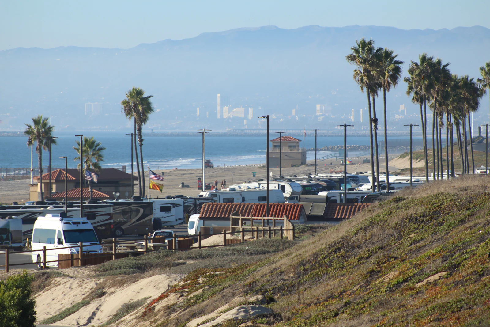 RVs parked along the coast near Mission Bay San Diego with the downtown skyline in the distance