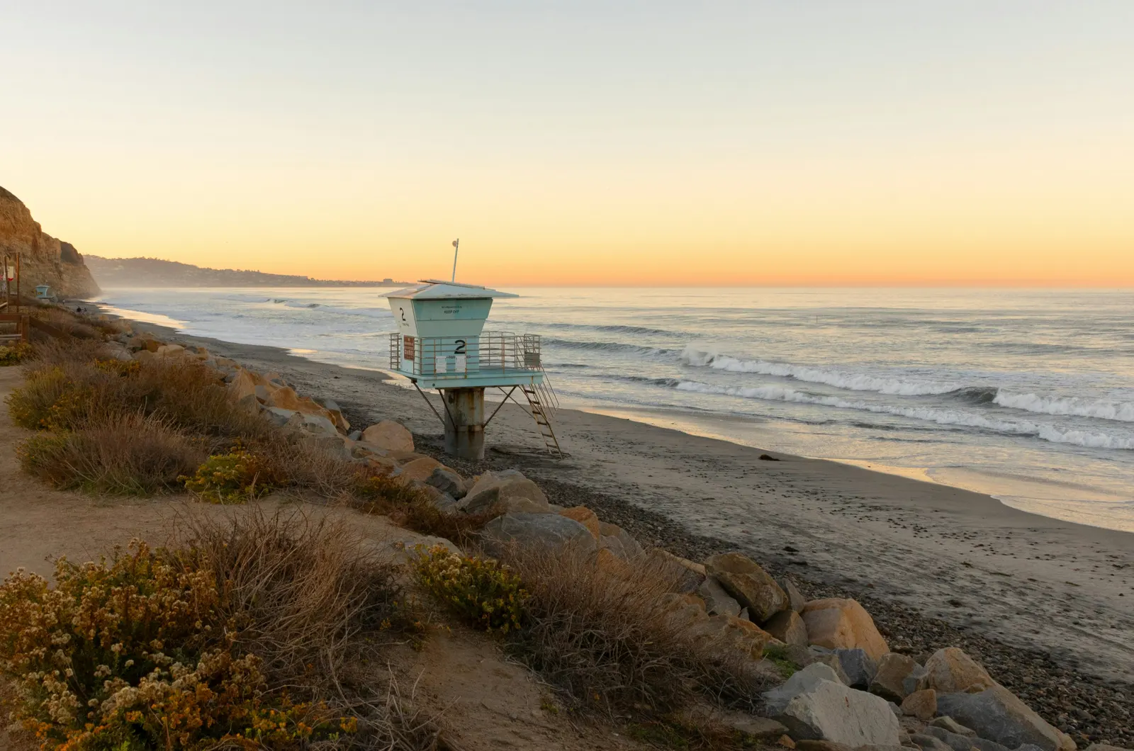Lifeguard tower on a Torrey Pines beach at sunset with golden light on the sand