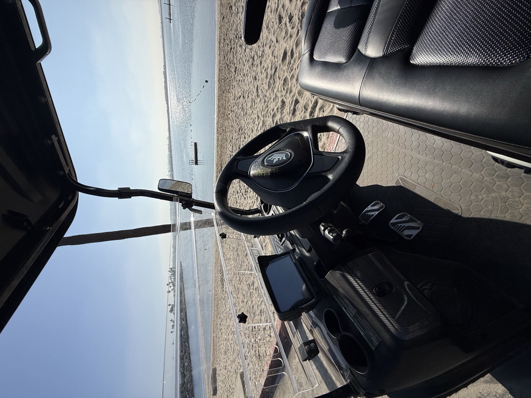 Black Beach Mode Rentals golf cart parked on the sand at a San Diego beach