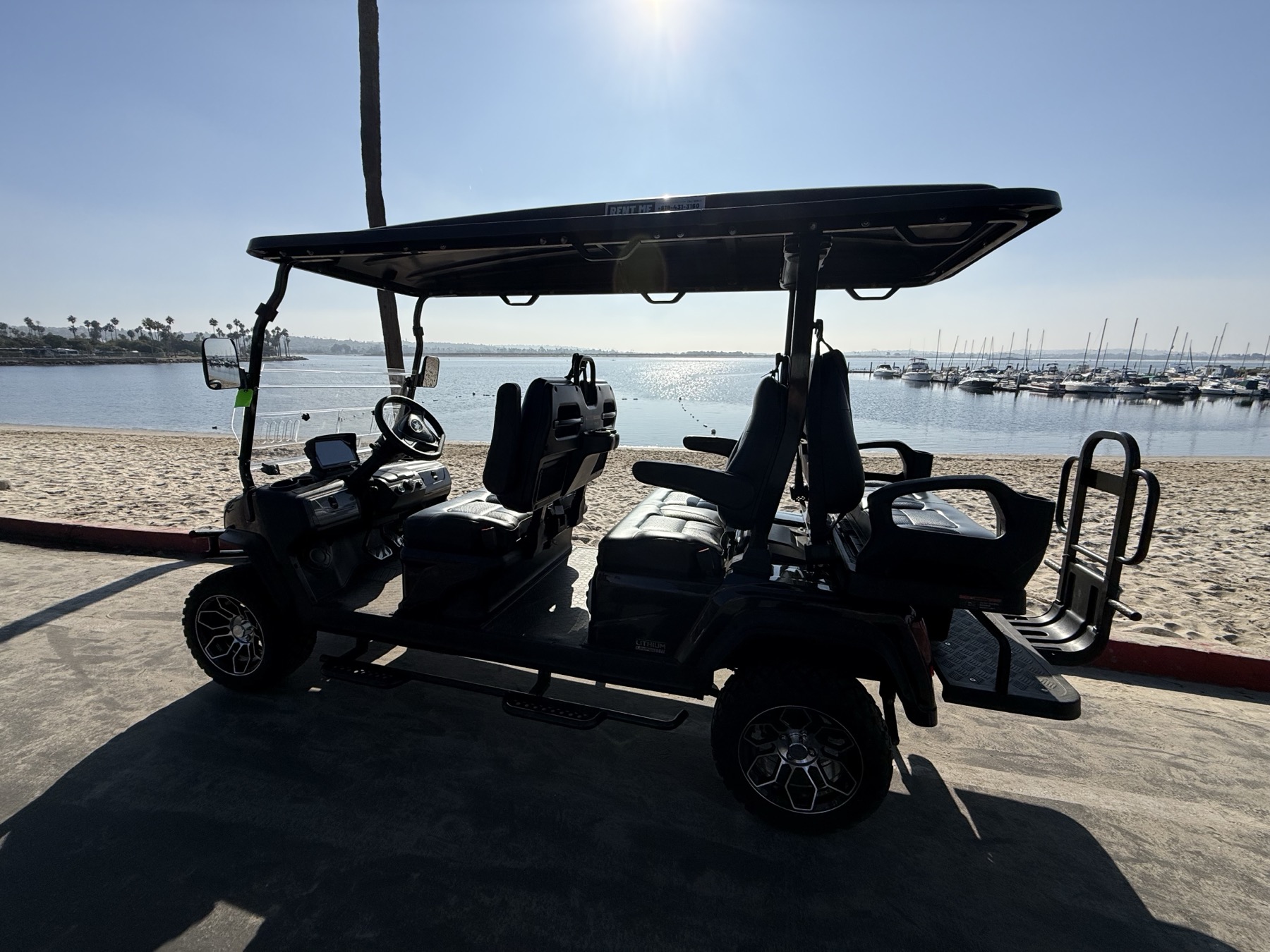 Black Beach Mode Rentals Maverick golf cart parked on the sand at a San Diego beach